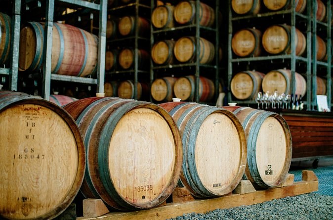 Oak barrels stacked on racks in a winery's barrel room