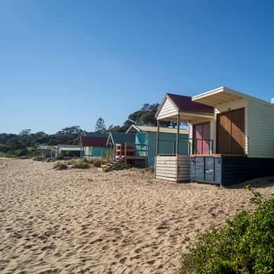 Bathing boxes along a sandy bay beach on a clear morning