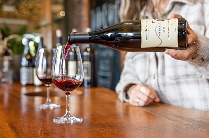 Red wine poured into tasting glasses at a cellar-door bar